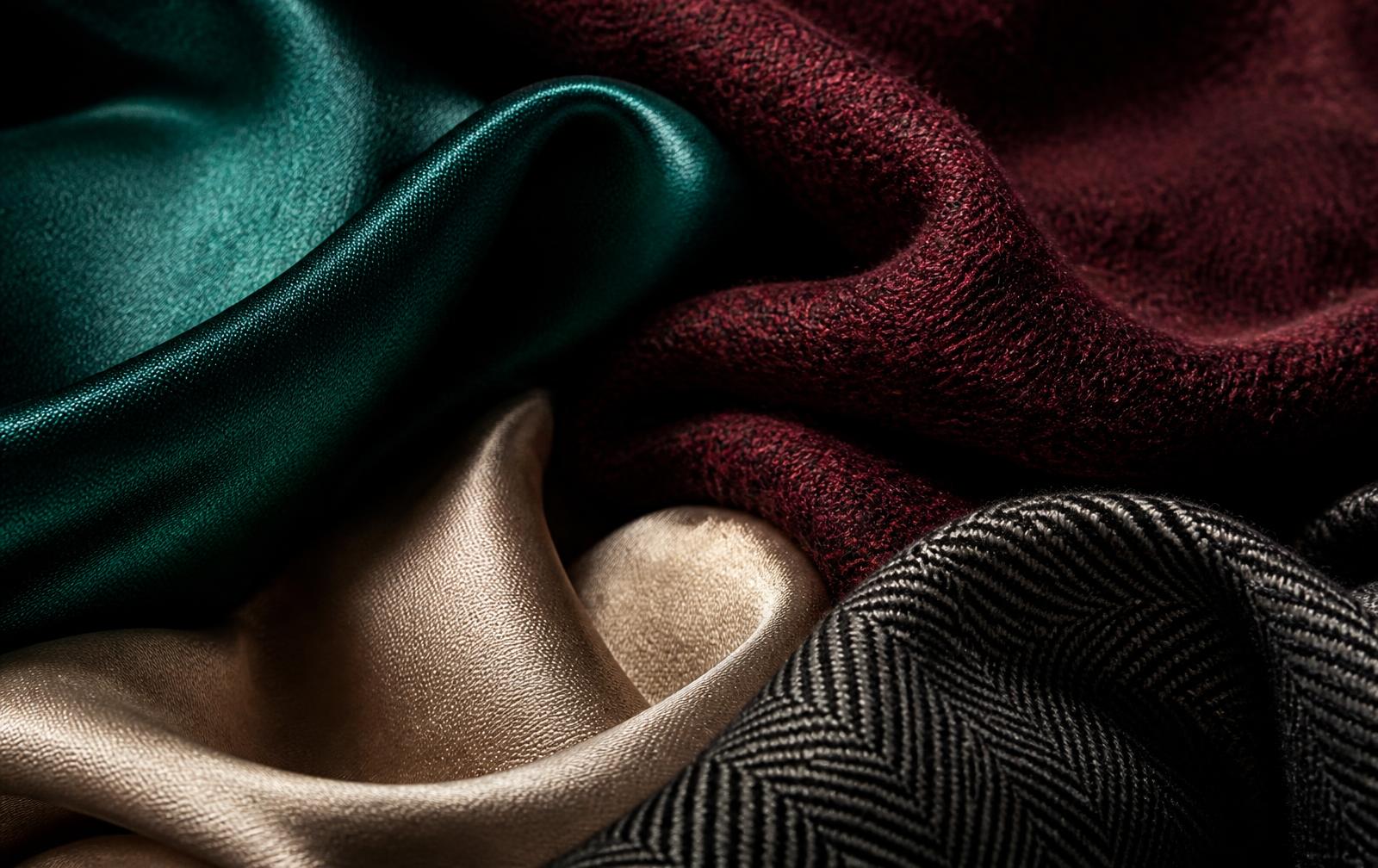 Emerald silk, burgundy wool, champagne satin and charcoal herringbone fabrics layered together